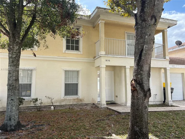 front view of a house with a tree in front of it