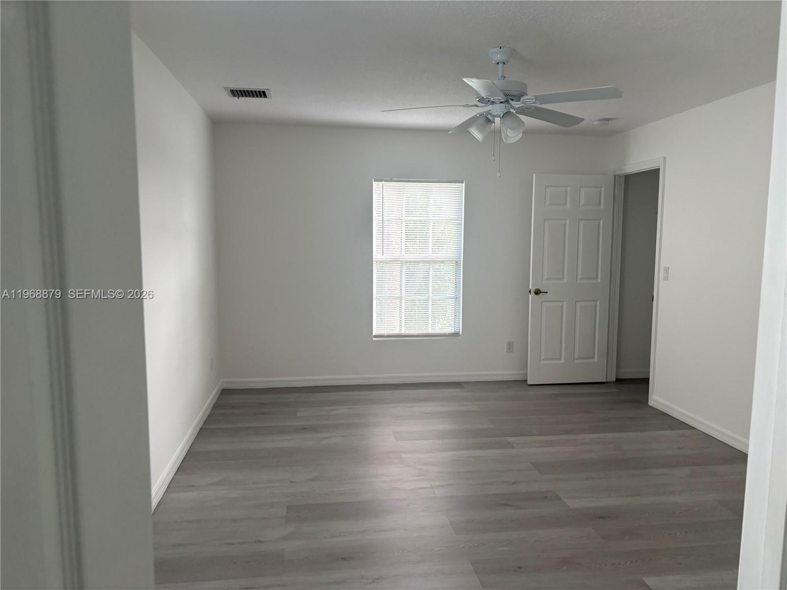 3836 Dove Landing Road West Palm Beach, FL 33403 - Photo 28 of 53 a view of an empty room with a window and wooden floor