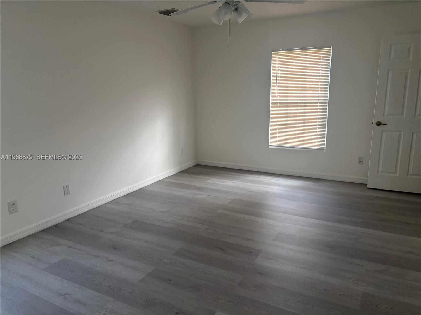 3836 Dove Landing Road West Palm Beach, FL 33403 - Photo 29 of 53 an empty room with wooden floor and windows