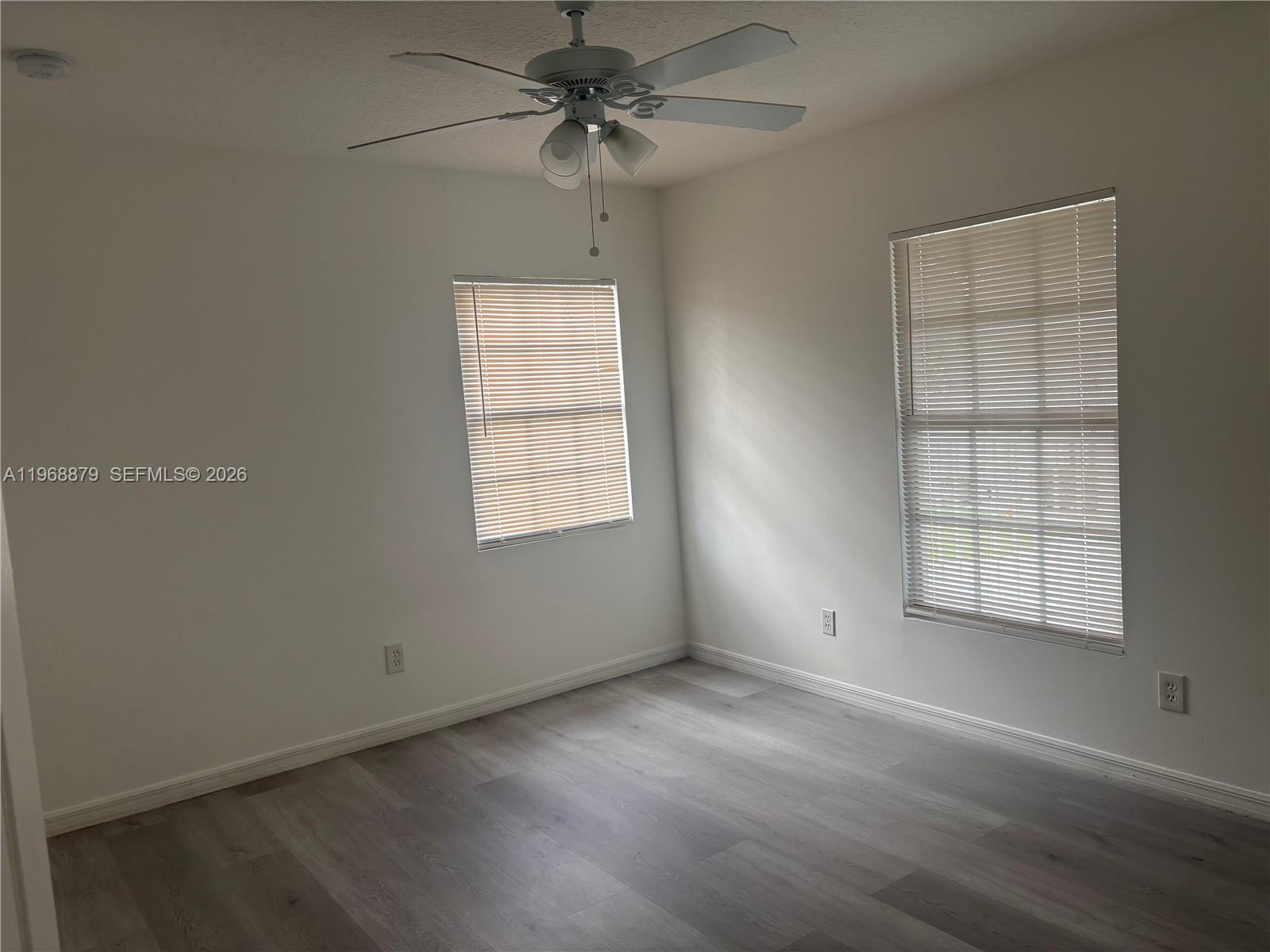 3836 Dove Landing Road West Palm Beach, FL 33403 - Photo 34 of 53 an empty room with wooden floor fan and windows