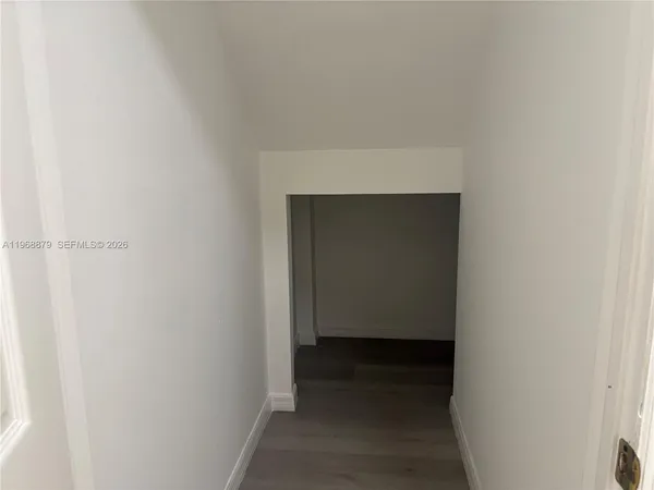 an empty room with windows and ceiling fan