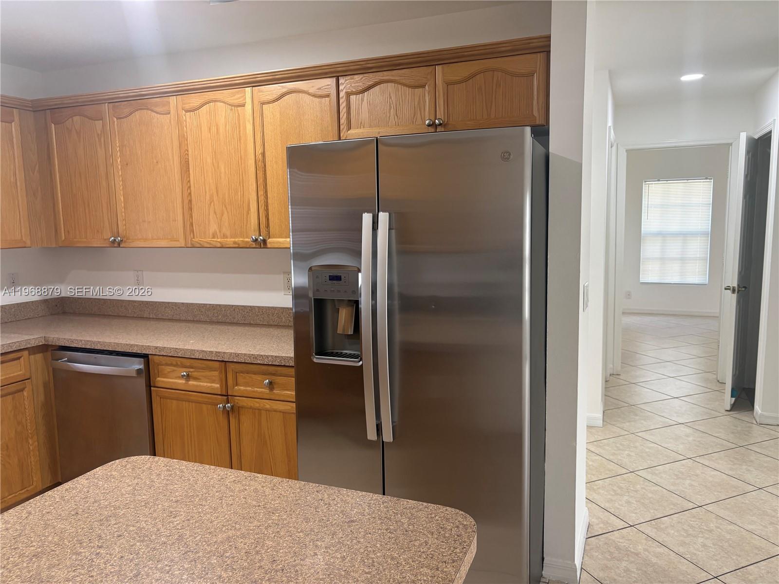 3836 Dove Landing Road West Palm Beach, FL 33403 - Photo 51 of 53 a kitchen with kitchen island a counter top space cabinets and a refrigerator