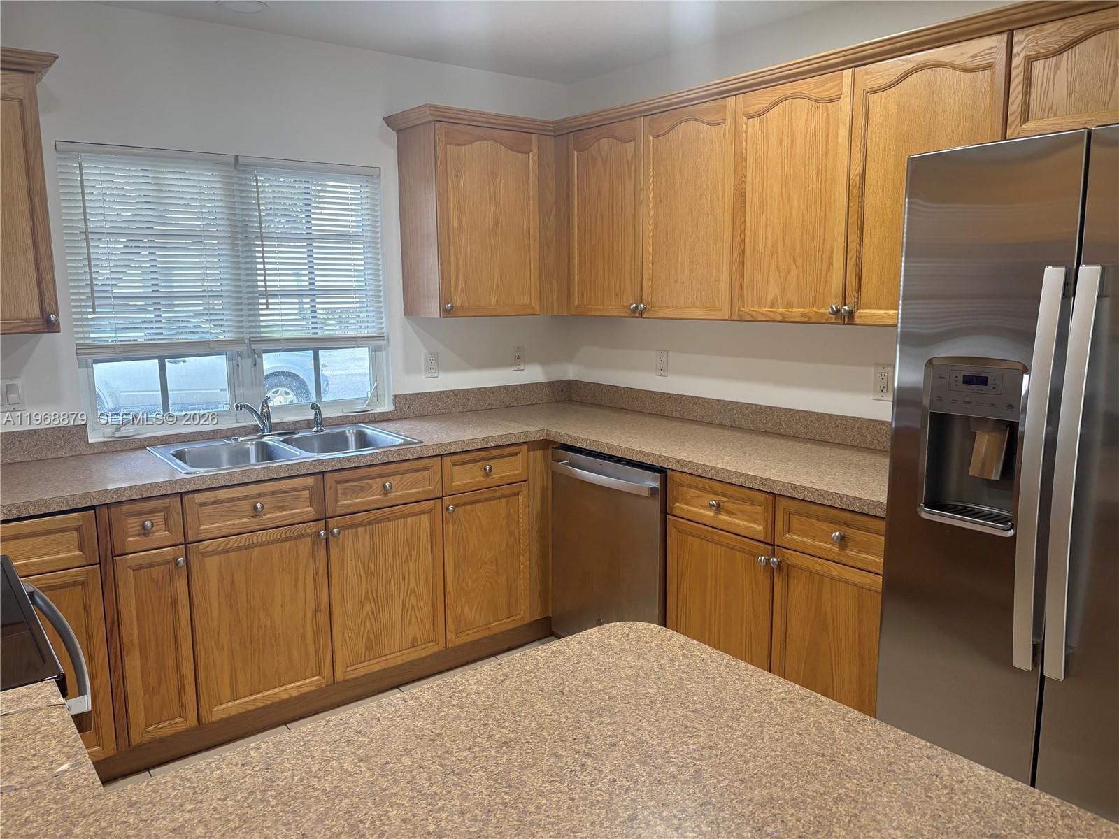 3836 Dove Landing Road West Palm Beach, FL 33403 - Photo 52 of 53 a kitchen with stainless steel appliances granite countertop a refrigerator sink and cabinets