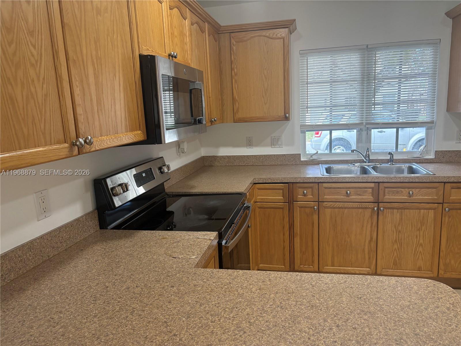 3836 Dove Landing Road West Palm Beach, FL 33403 - Photo 53 of 53 a kitchen with stainless steel appliances granite countertop a sink a stove and a microwave
