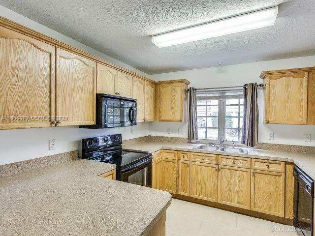 3836 Dove Landing Road West Palm Beach, FL 33403 - Photo 8 of 53 a kitchen with stainless steel appliances granite countertop a sink stove and cabinets