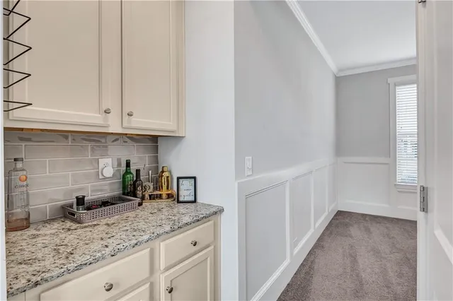 a kitchen with granite countertop a sink and white cabinets