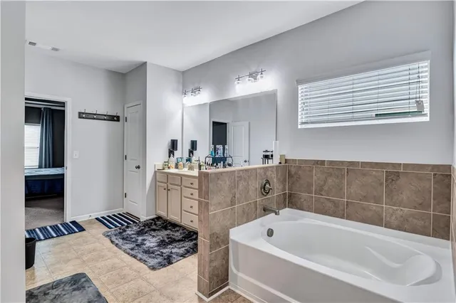 a bathroom with a sink a bath tub and a mirror
