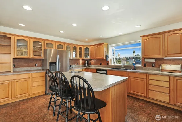 a kitchen with stainless steel appliances granite countertop a sink a stove top oven a counter space and cabinets