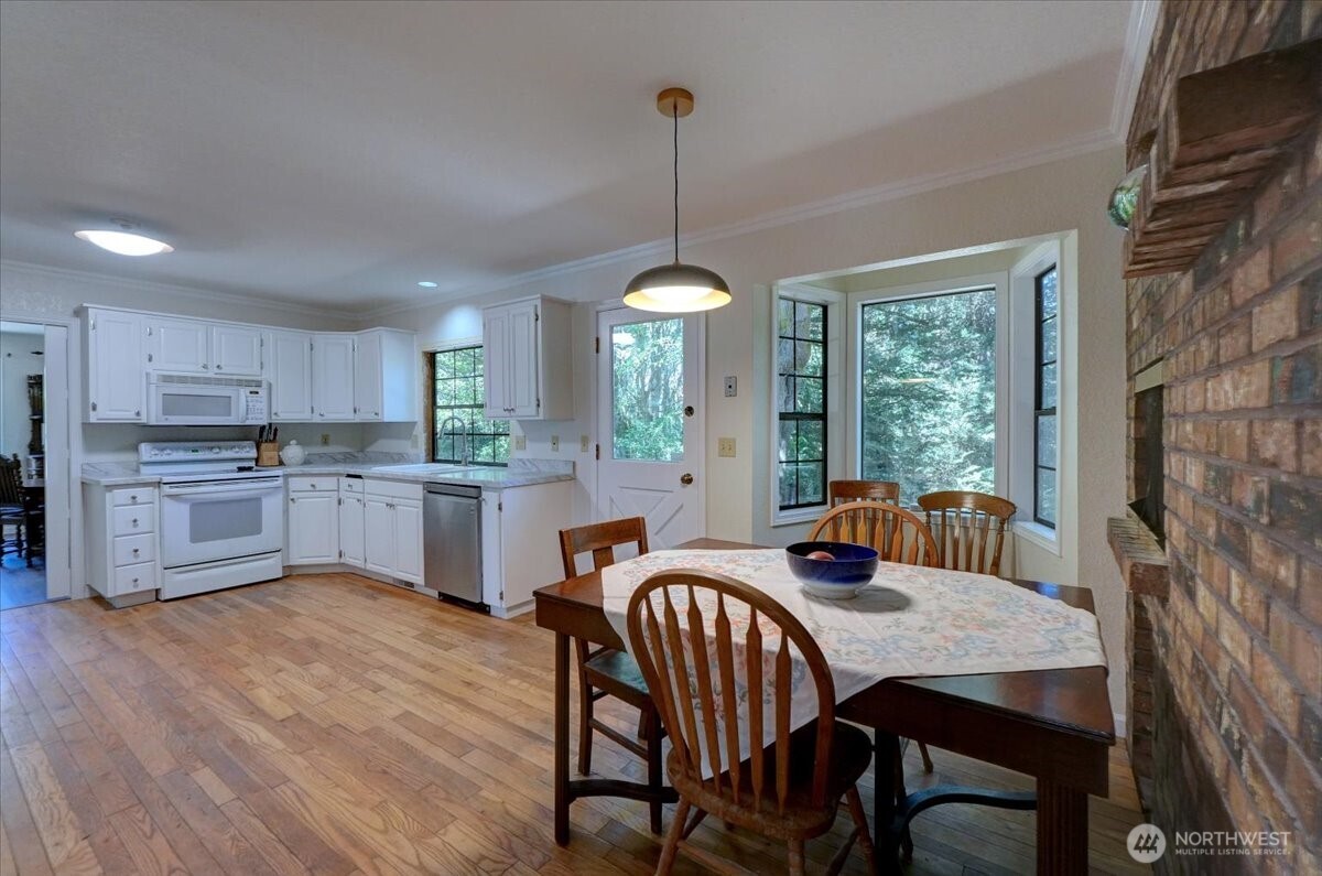 680 Southeast Prospect Street Chehalis, WA 98532 - Photo 9 of 39 a kitchen with kitchen island a dining table chairs stainless steel appliances and cabinets