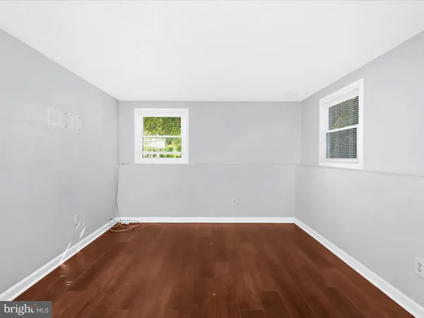 an empty room with wooden floor and window