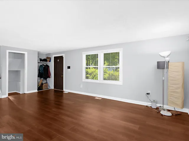 an empty room with wooden floor and closet