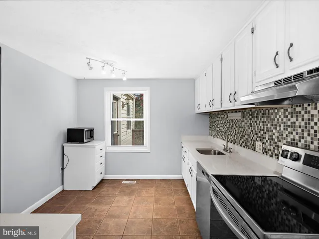 a kitchen with a stove and white cabinets