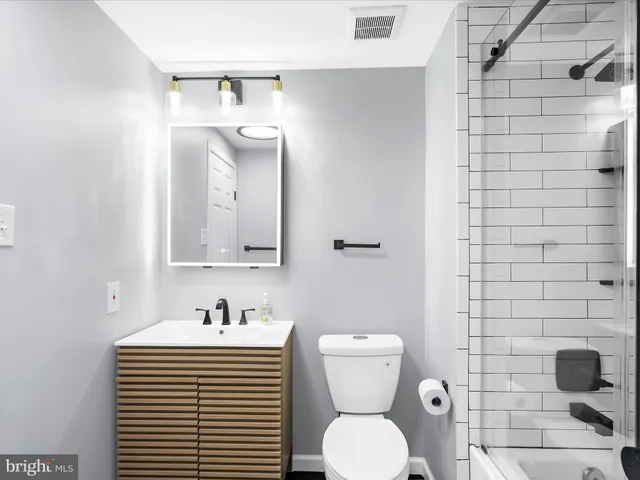 a bathroom with a sink a toilet and mirror