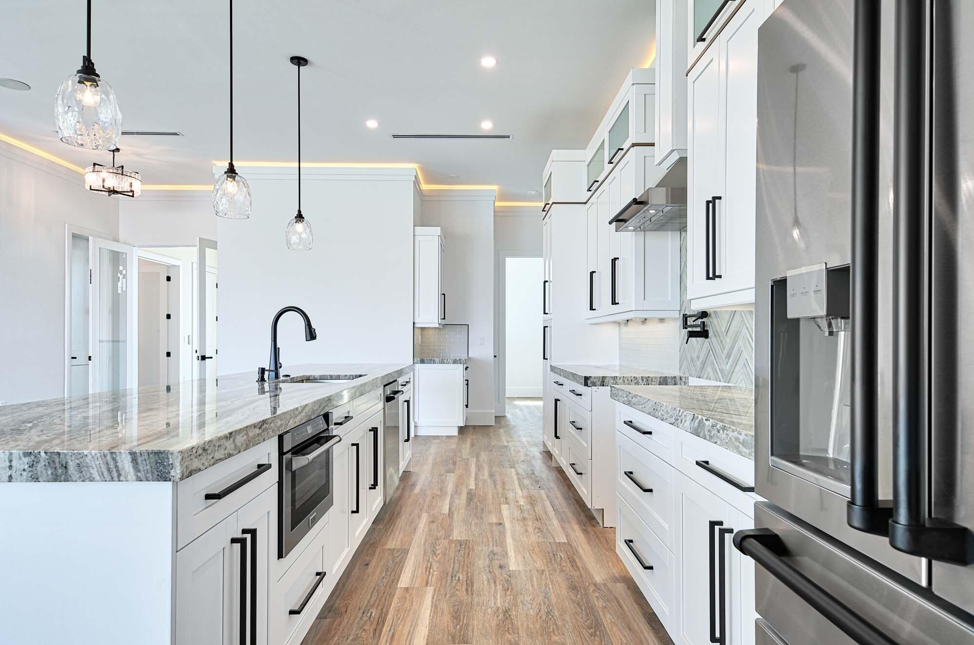 143 Trinidad Street Naples, FL 34113 - Photo 8 of 62 a large white kitchen with stainless steel appliances