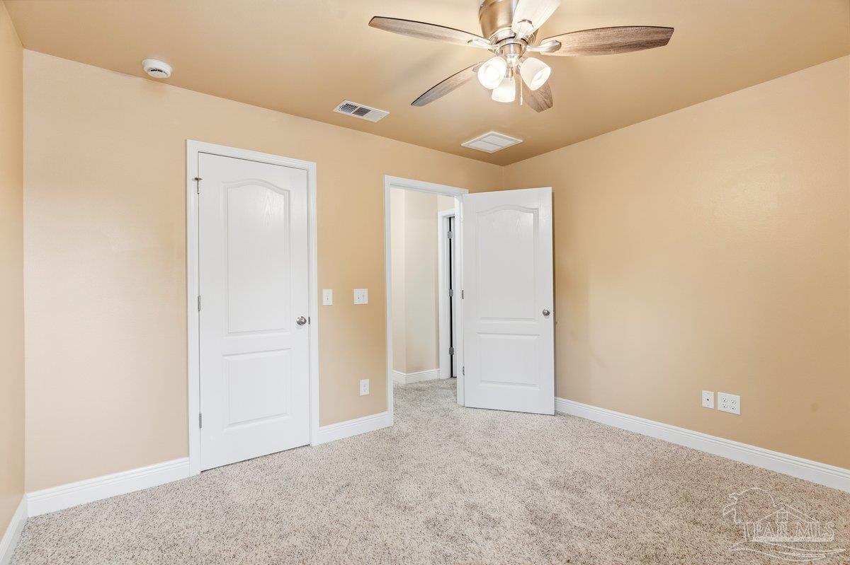 5468 Madelines Way Pace, FL 32571 - Photo 11 of 46 an empty room with closet and a chandelier fan