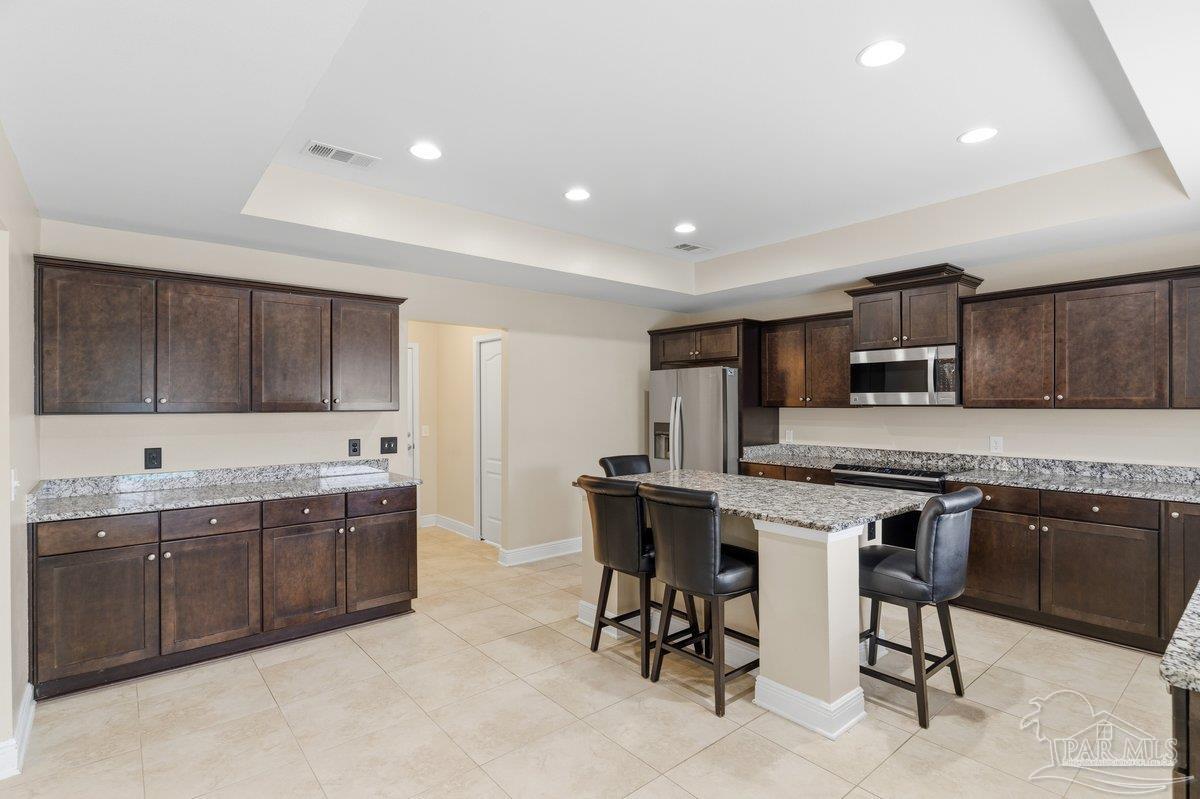 5468 Madelines Way Pace, FL 32571 - Photo 15 of 46 a kitchen with stainless steel appliances kitchen island granite countertop a sink and cabinets