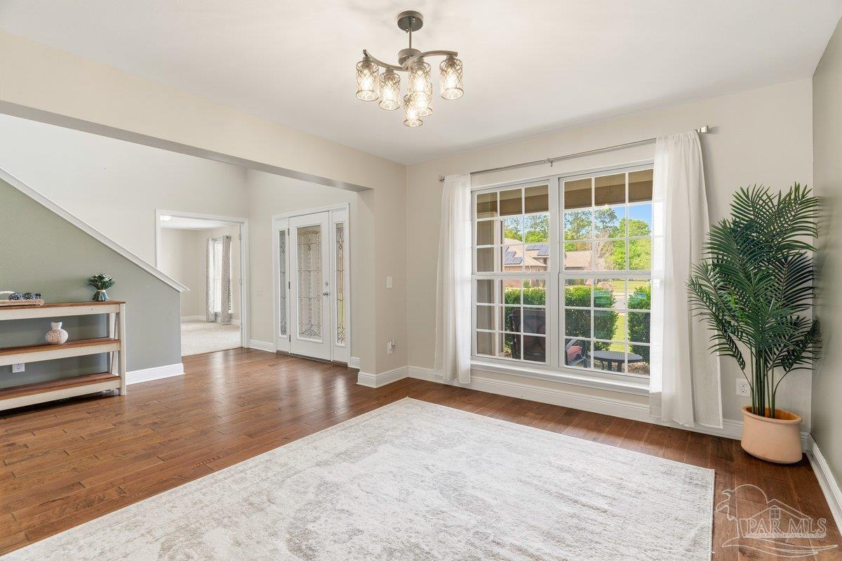 5468 Madelines Way Pace, FL 32571 - Photo 20 of 46 a view of an empty room with a window and wooden floor