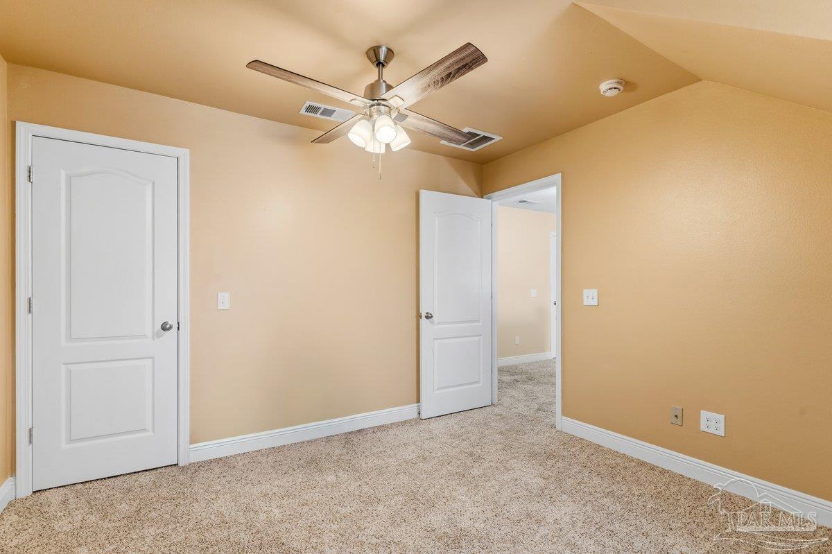 5468 Madelines Way Pace, FL 32571 - Photo 23 of 46 an empty room with a ceiling fan and a window
