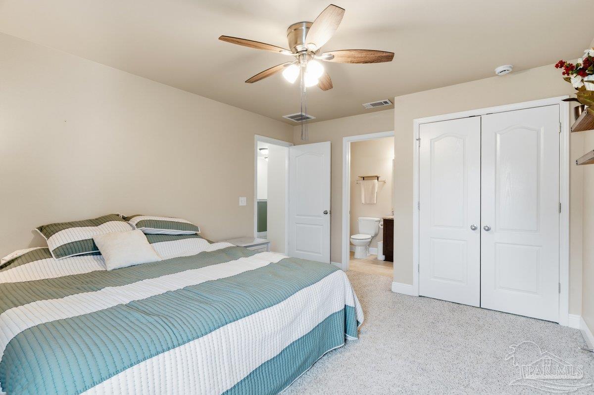 5468 Madelines Way Pace, FL 32571 - Photo 25 of 46 a bedroom with a bed and a ceiling fan