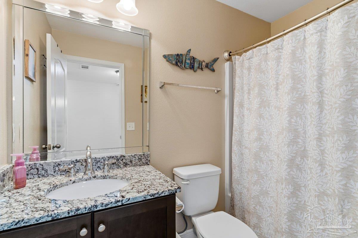5468 Madelines Way Pace, FL 32571 - Photo 27 of 46 a bathroom with a granite countertop sink toilet and a mirror