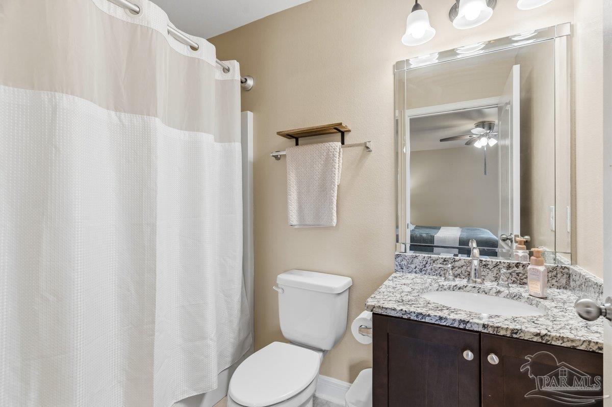 5468 Madelines Way Pace, FL 32571 - Photo 28 of 46 a bathroom with a granite countertop sink toilet and shower