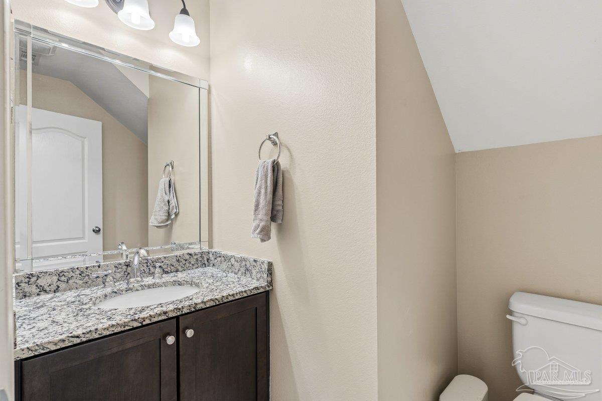 5468 Madelines Way Pace, FL 32571 - Photo 29 of 46 a bathroom with a granite countertop sink toilet and mirror