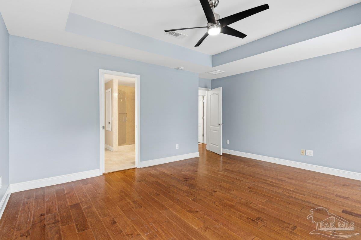 5468 Madelines Way Pace, FL 32571 - Photo 31 of 46 a view of an empty room with wooden floor and a ceiling fan