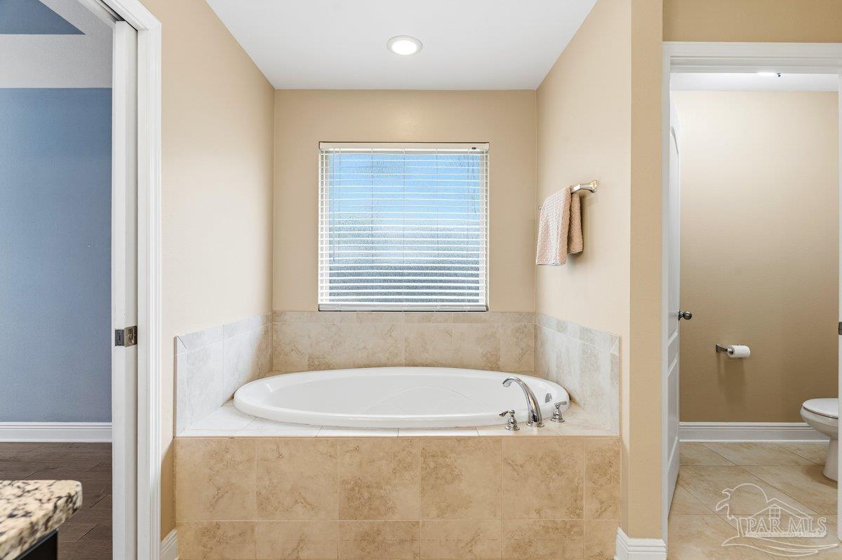 5468 Madelines Way Pace, FL 32571 - Photo 34 of 46 a bathroom with a bathtub and a shower