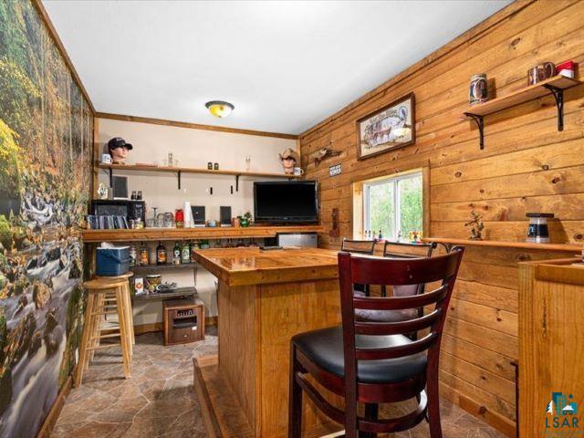 3616 Lavaque Road Hermantown, MN 55811 - Photo 25 of 43 Recreation space featuring a built-in wood bar with a polished countertop, natural wood plank walls, and stone-look tile flooring