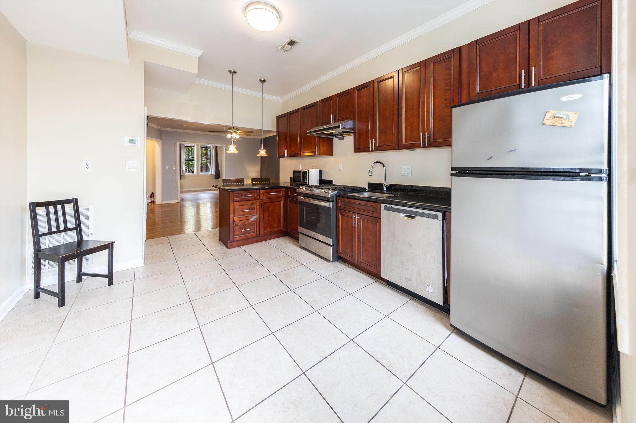 1388 Northeast E Street Northeast Washington, DC 20002 - Photo 3 of 28 a kitchen with stainless steel appliances granite countertop a refrigerator and a stove top oven