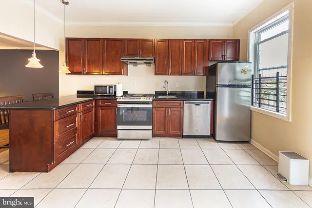 a kitchen with stainless steel appliances granite countertop a stove a sink dishwasher and a refrigerator