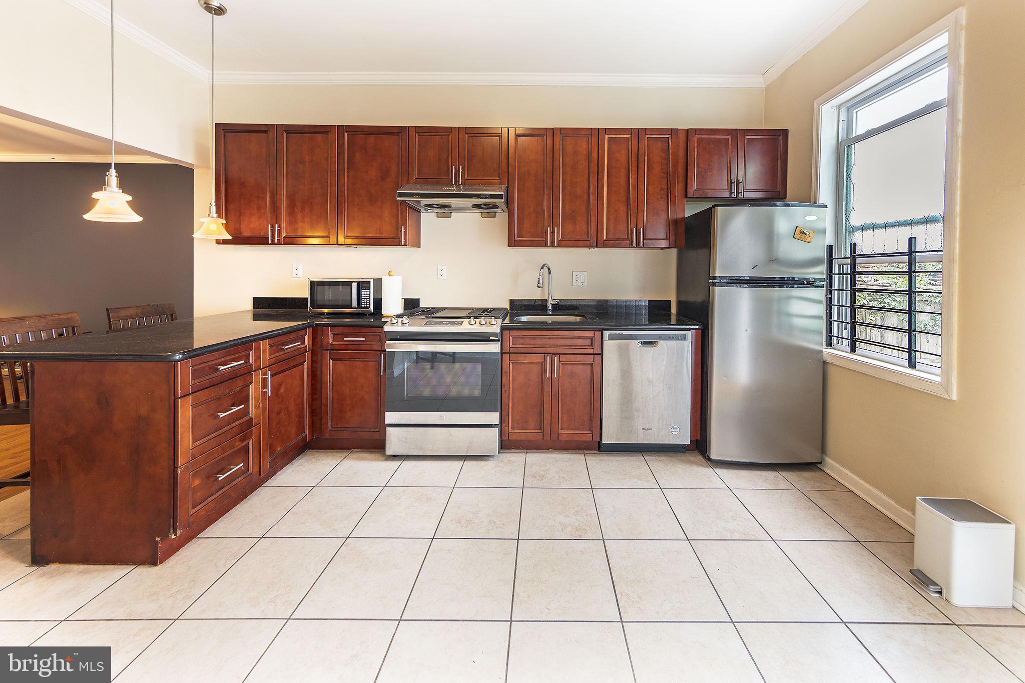 1388 Northeast E Street Northeast Washington, DC 20002 - Photo 4 of 28 a kitchen with stainless steel appliances granite countertop a stove a sink dishwasher and a refrigerator