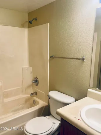 a bathroom with a sink a toilet a mirror a bathtub and shower