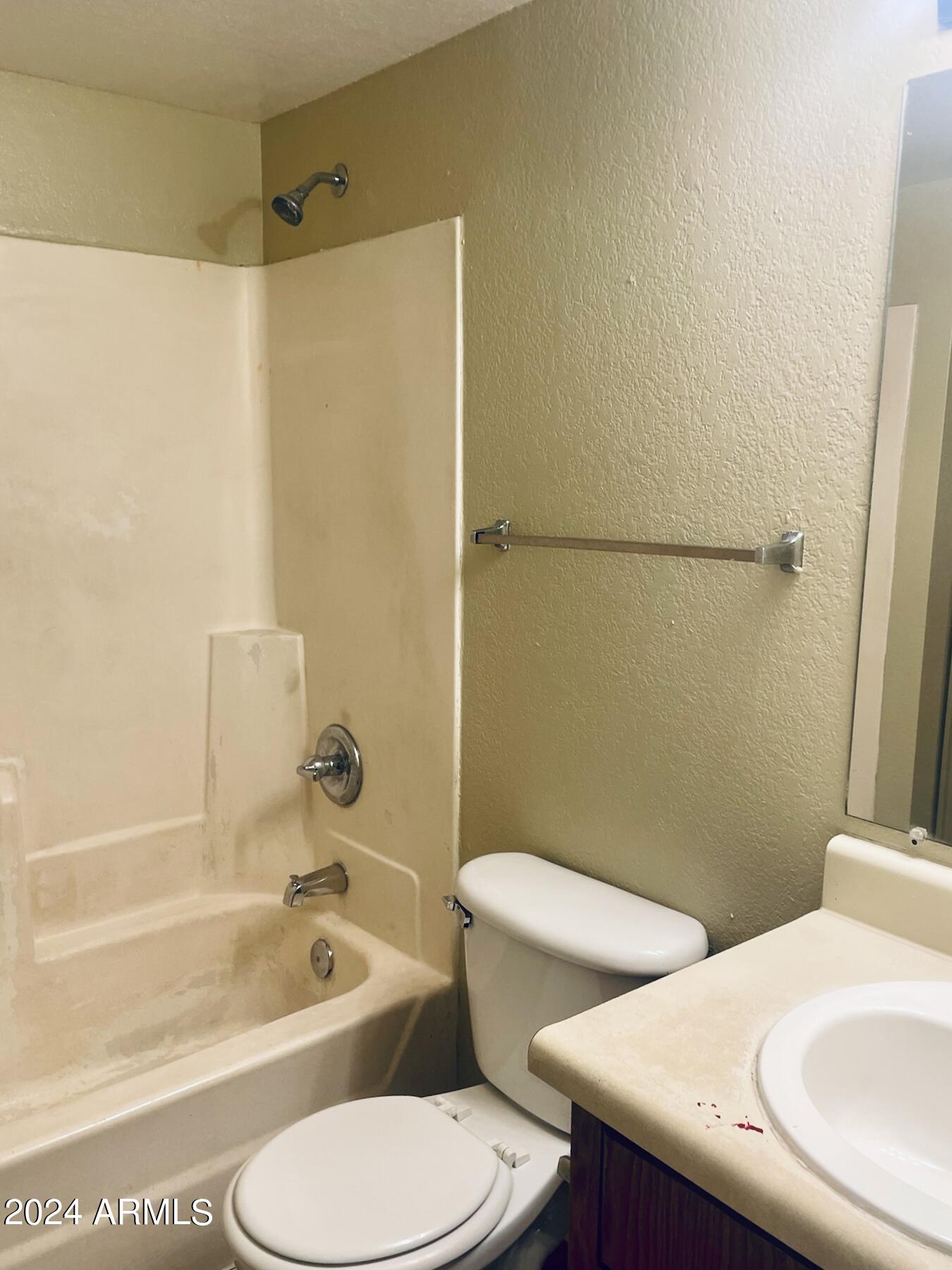 2846 East Kathleen Road, Unit 103 Phoenix, AZ 85032 - Photo 14 of 17 a bathroom with a sink a toilet a mirror a bathtub and shower