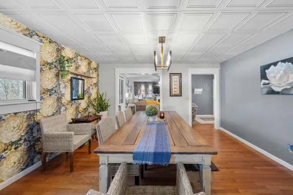a view of a dining room with furniture a chandelier and wooden floor