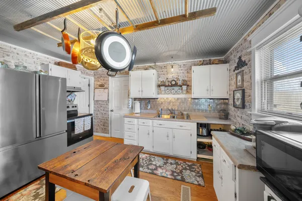 a kitchen with stainless steel appliances granite countertop a sink a stove and a refrigerator