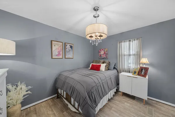 a bedroom with a large bed and a chandelier