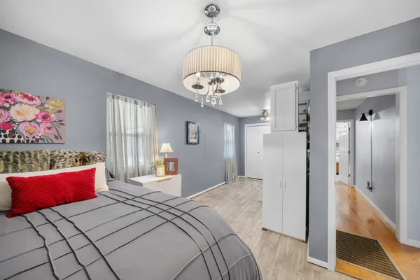 a bedroom with bed and a chandelier