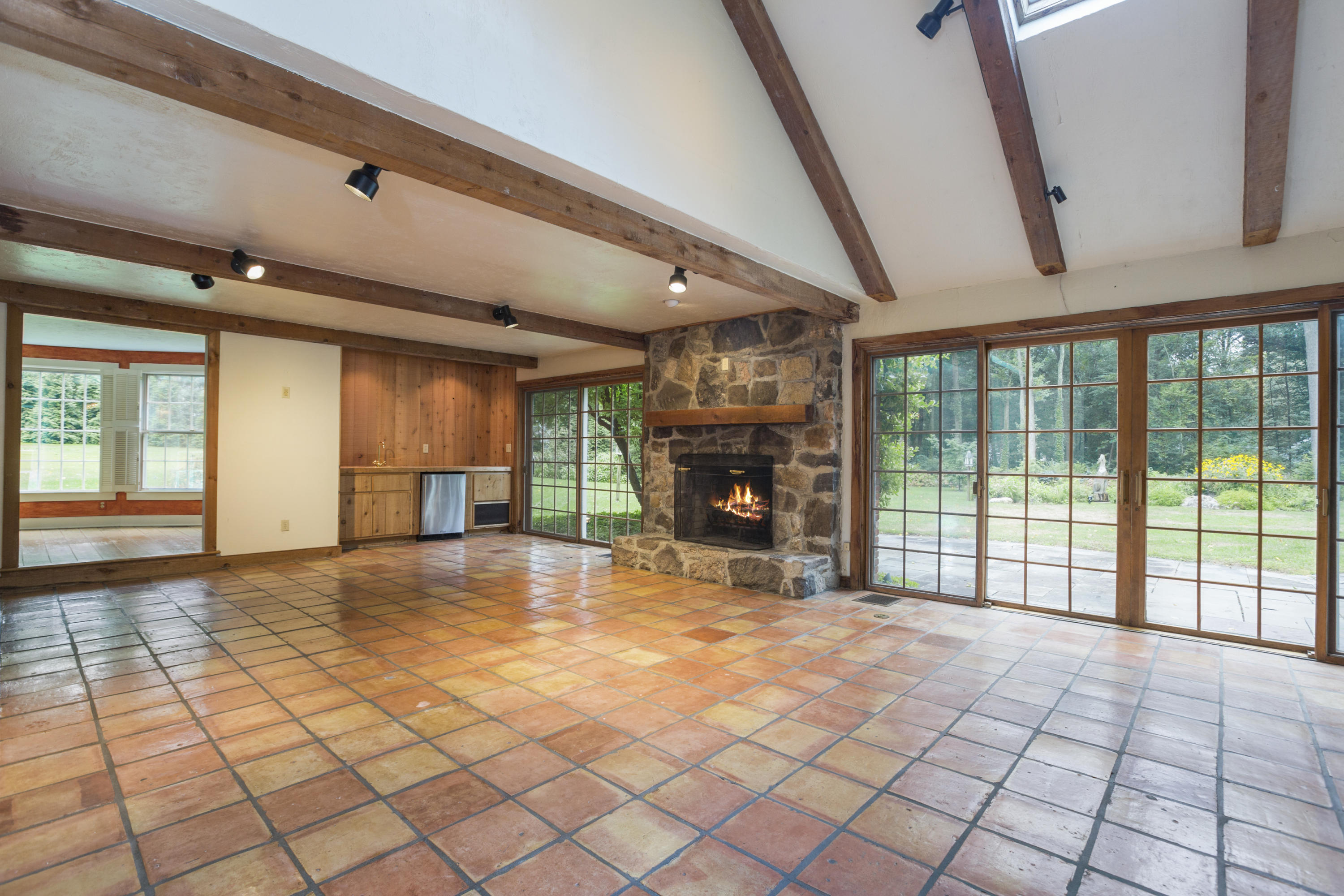 283 Hollow Tree Ridge Road Darien, CT 06820 - Photo 16 of 49 a view of an empty room with a fireplace and a large window