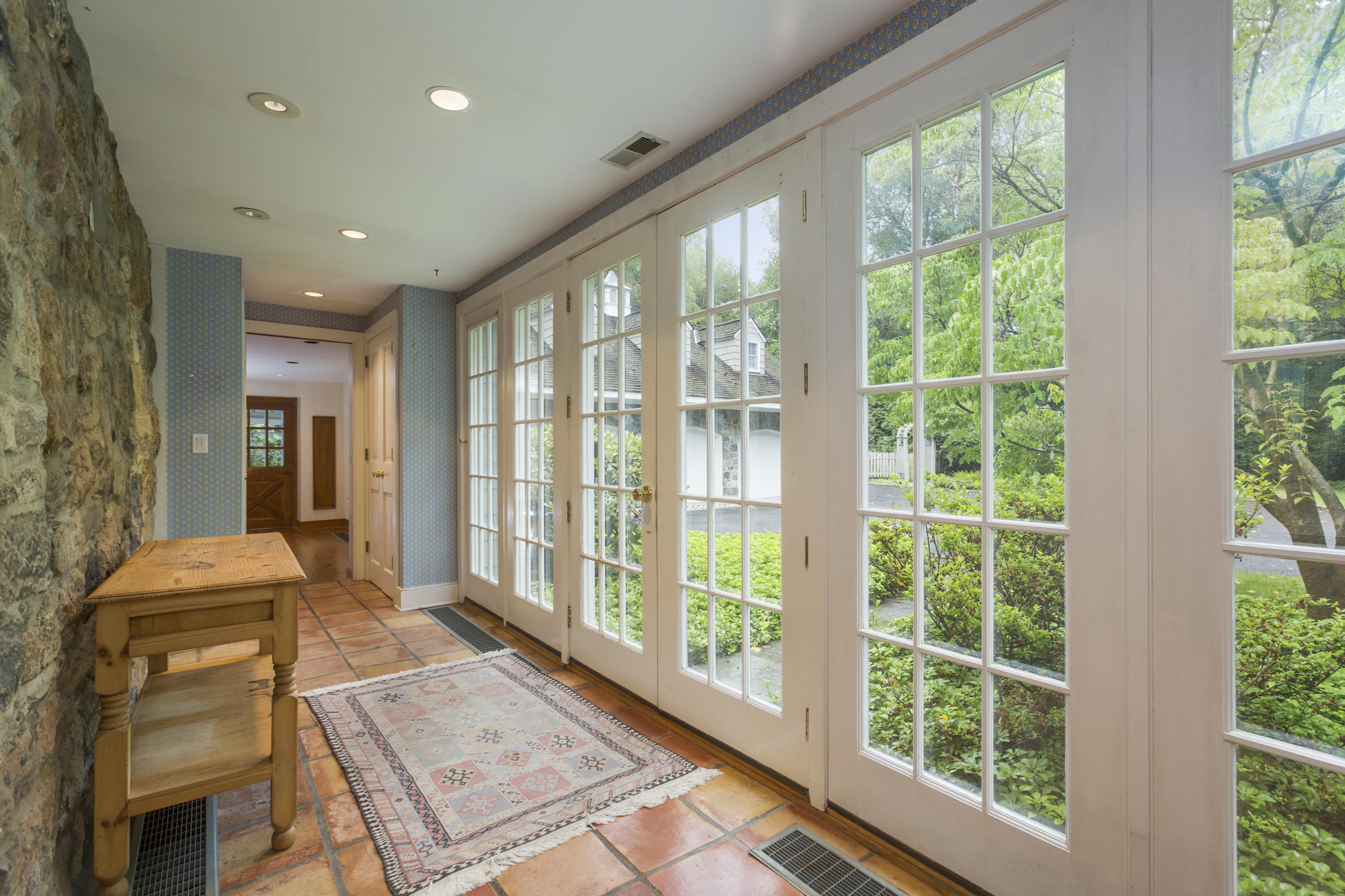 283 Hollow Tree Ridge Road Darien, CT 06820 - Photo 20 of 49 a living room with large windows and a table