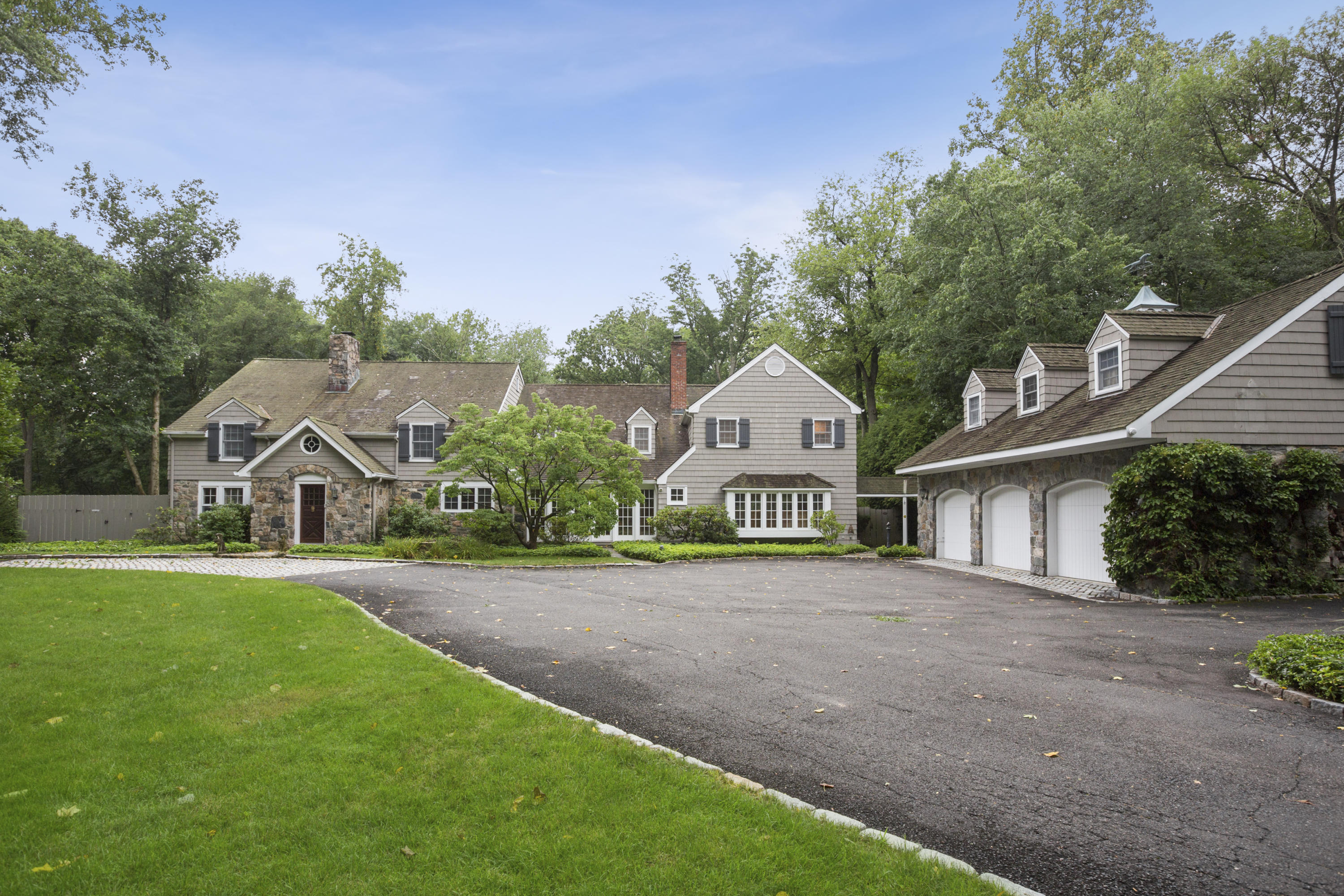 283 Hollow Tree Ridge Road Darien, CT 06820 - Photo 2 of 49 a front view of a house with a yard and garage