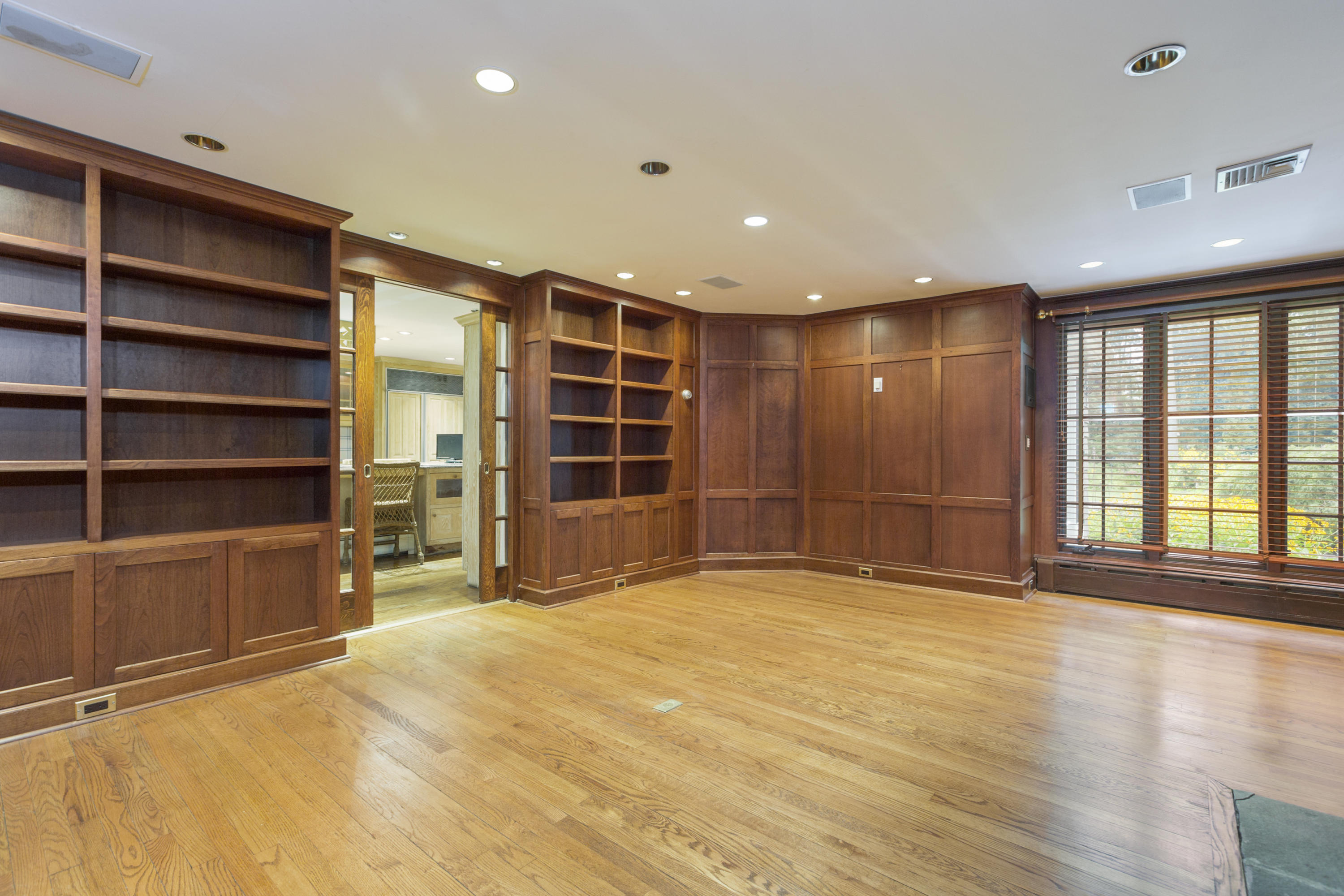283 Hollow Tree Ridge Road Darien, CT 06820 - Photo 22 of 49 a view of an empty room with a fireplace and cabinets