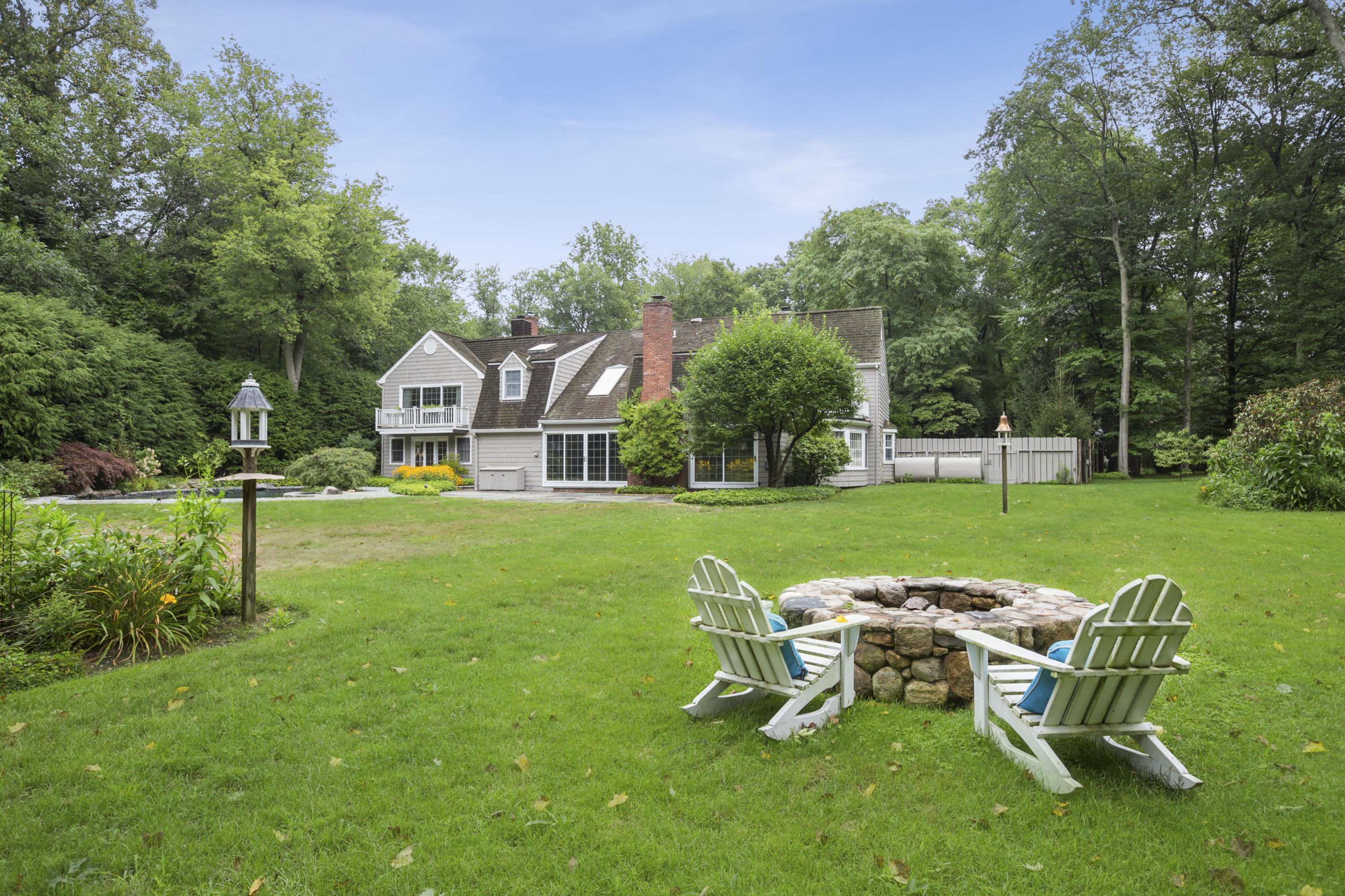 283 Hollow Tree Ridge Road Darien, CT 06820 - Photo 34 of 49 a view of a patio with table and chairs potted plants and a large tree