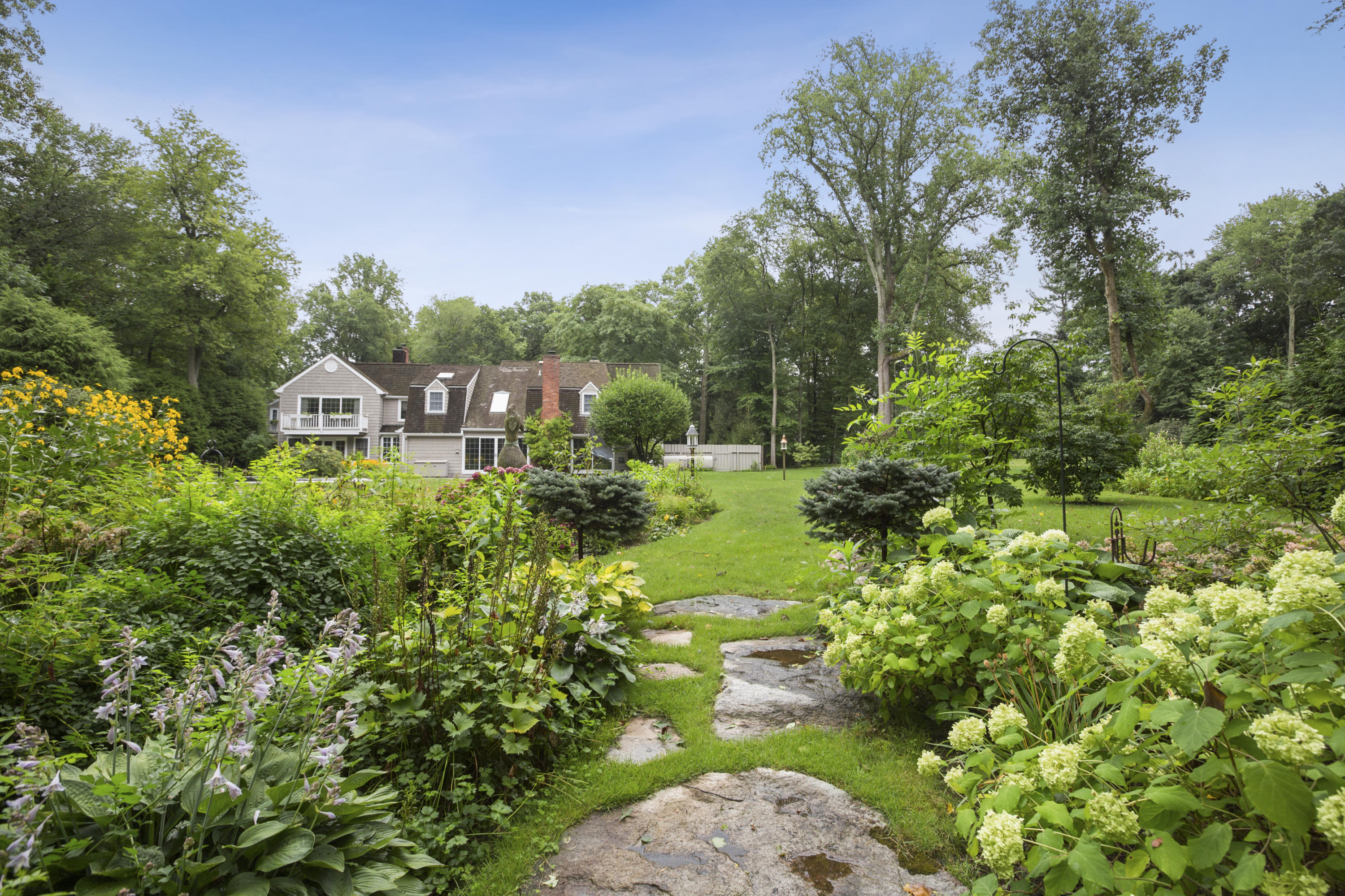 283 Hollow Tree Ridge Road Darien, CT 06820 - Photo 44 of 49 a view of a garden with a house in a yard