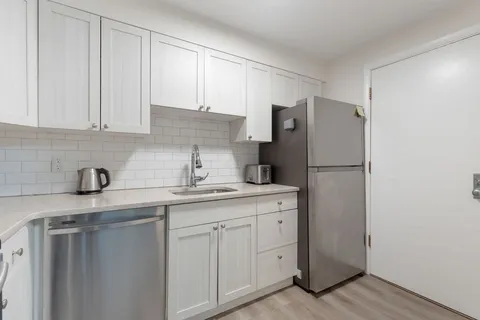 a kitchen with appliances a sink and cabinets