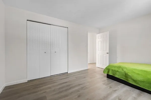 a view of room with hardwood floor and closet