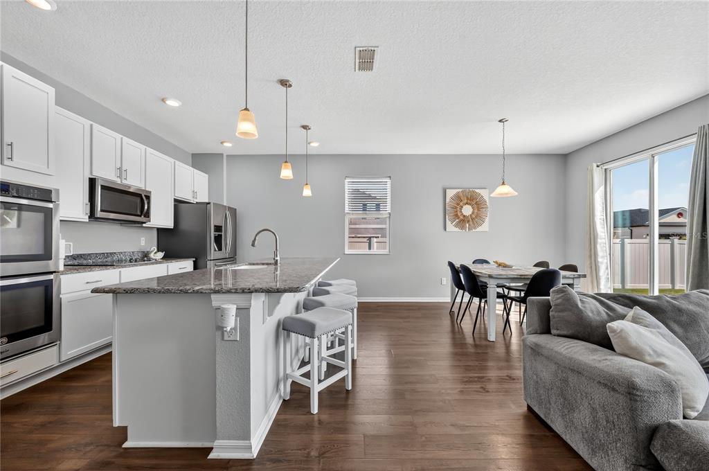 4368 Moon Shadow Loop Mulberry, FL 33860 - Photo 13 of 39 a living room with stainless steel appliances furniture and a wooden floor