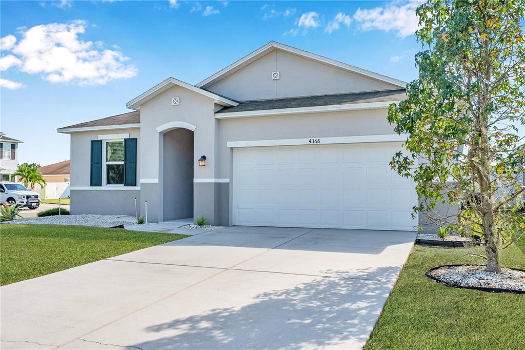 4368 Moon Shadow Loop Mulberry, FL 33860 - Photo 3 of 39 a front view of a house with a yard and garage