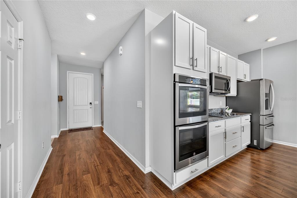 4368 Moon Shadow Loop Mulberry, FL 33860 - Photo 4 of 39 a kitchen with stainless steel appliances granite countertop a refrigerator microwave and stove top oven