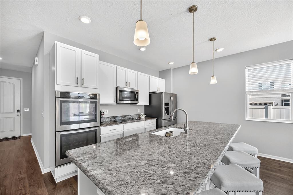 4368 Moon Shadow Loop Mulberry, FL 33860 - Photo 5 of 39 a kitchen with stainless steel appliances granite countertop a sink refrigerator and cabinets